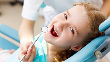Little girl smiling in dental exam chair