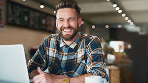 a smiling man sitting in a cafe