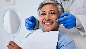 a woman smiling after getting a dental cleaning